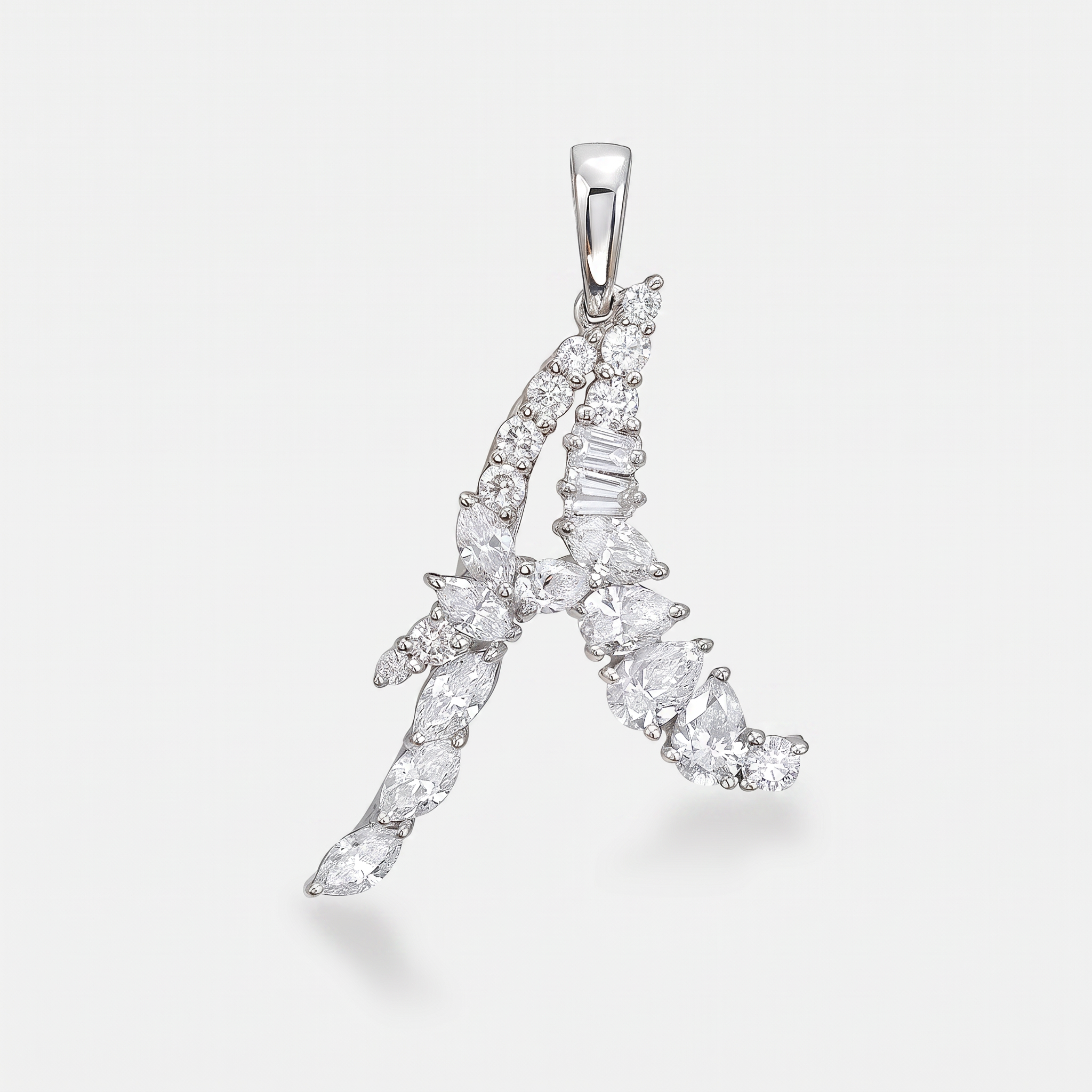 A white gold pendant shaped like the letter 'A', made from with mixed cut diamonds, shown on a light gray background.