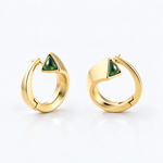 A pair of gold huggie hoop earrings with a triangular green stone accent on each earring, shown on a clean white background.