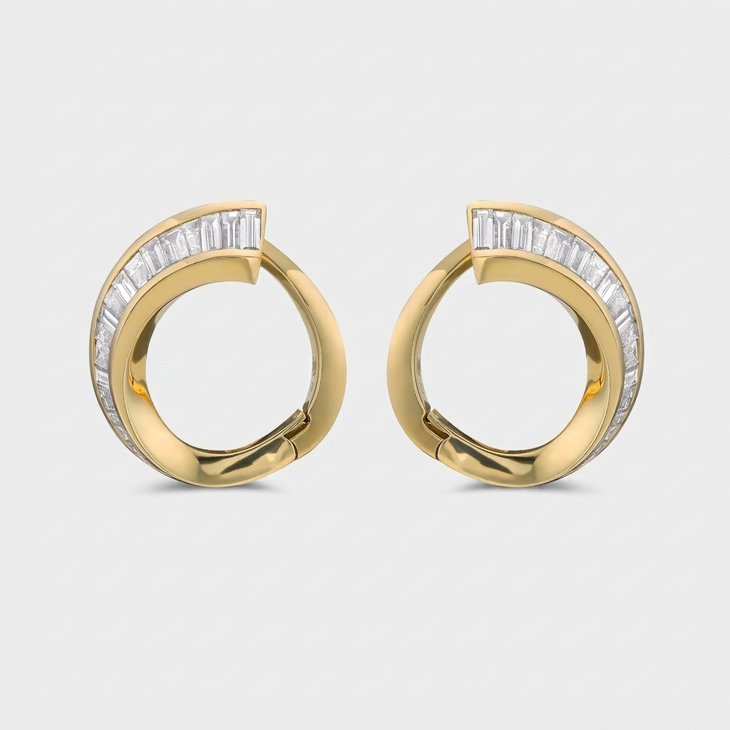 A pair of gold huggie hoop earrings with baguette-cut diamonds set along the front, shown on a light gray background.