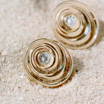 Spiral gold studs with a diamond on the center designed by Isabel Delgado