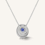 gold spiral pendant set with a tanzanite in the center designed by Isabel Delgado