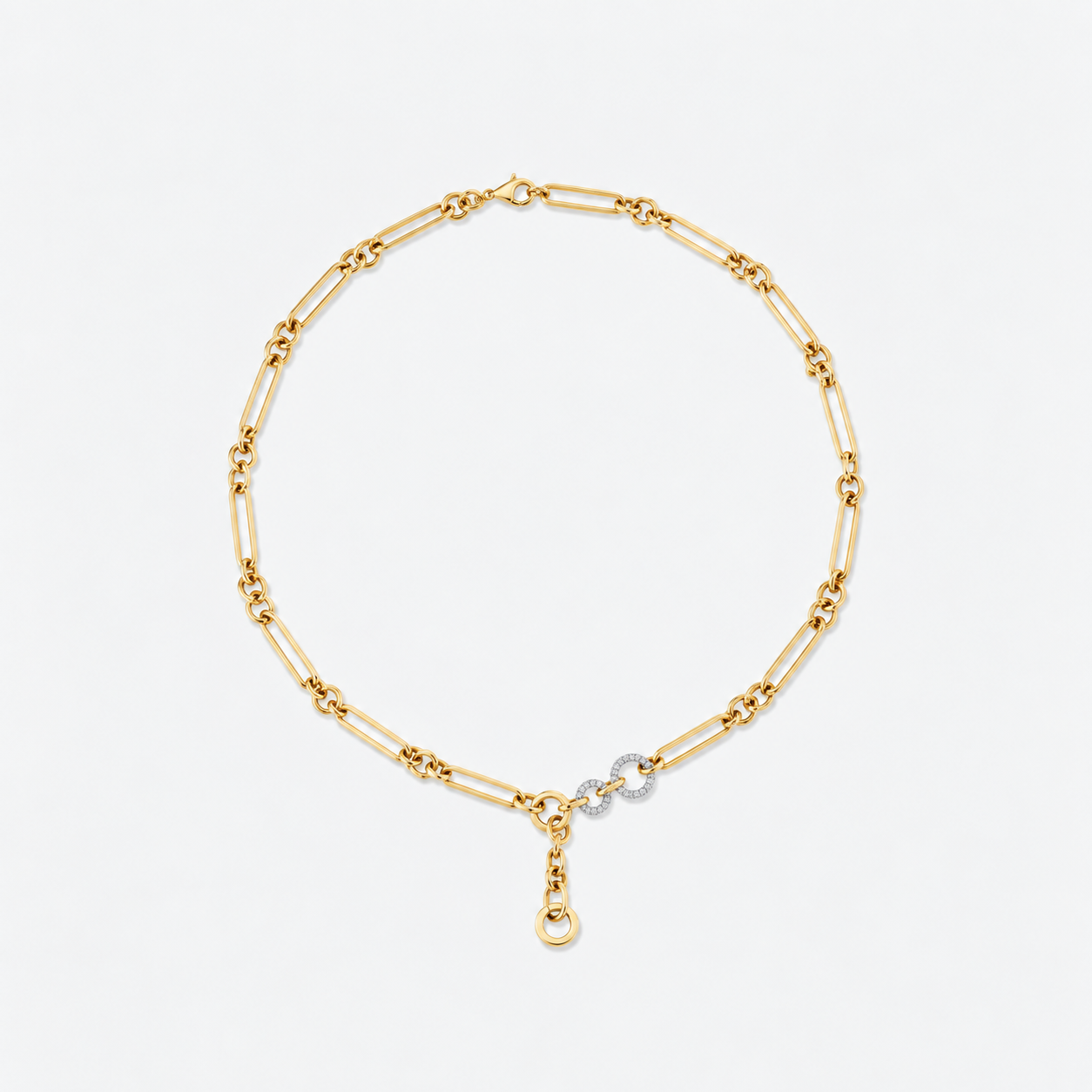 A gold paperclip chain necklace with a small silver-toned circular charm set with clear stones, featuring a gold lobster clasp at the bottom, photographed on a clean white background.