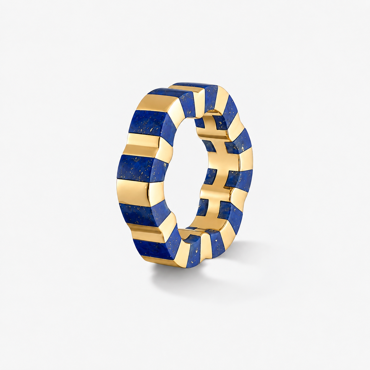 A sculptural gold ring featuring alternating textured blue lapis lazuli and gold geometric segments, shown on a clean white background.