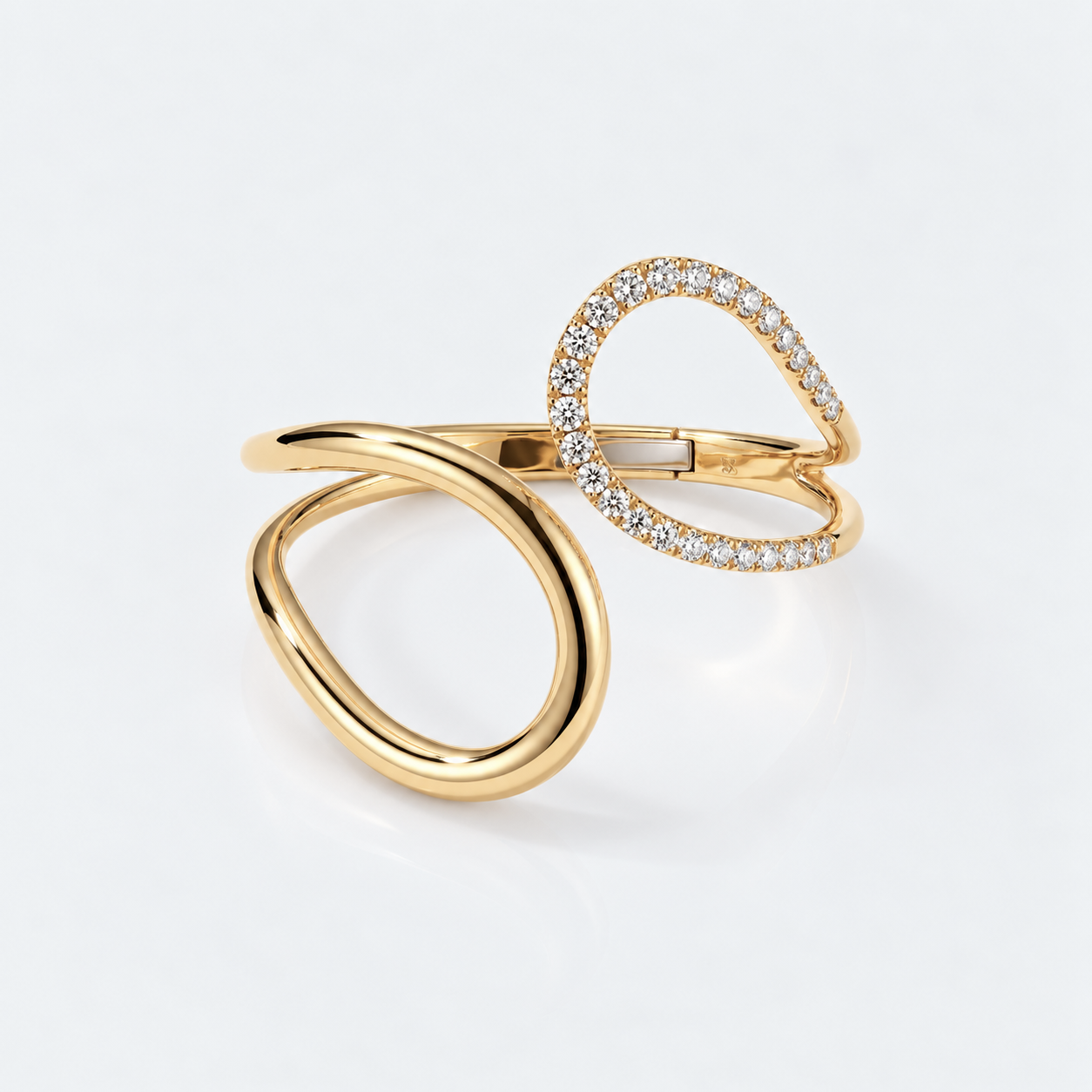 A gold open wrap ring featuring one smooth loop and one pavé-set diamond loop, photographed on a clean white background.