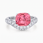 A cushion-cut pink gemstone ring set in a white gold pavé band, photographed on a clean white background.