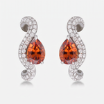 A single wave earring featuring a pear-cut orange gemstone surrounded by pavé-set clear stones on a curved white gold setting, shown against a light gray background.