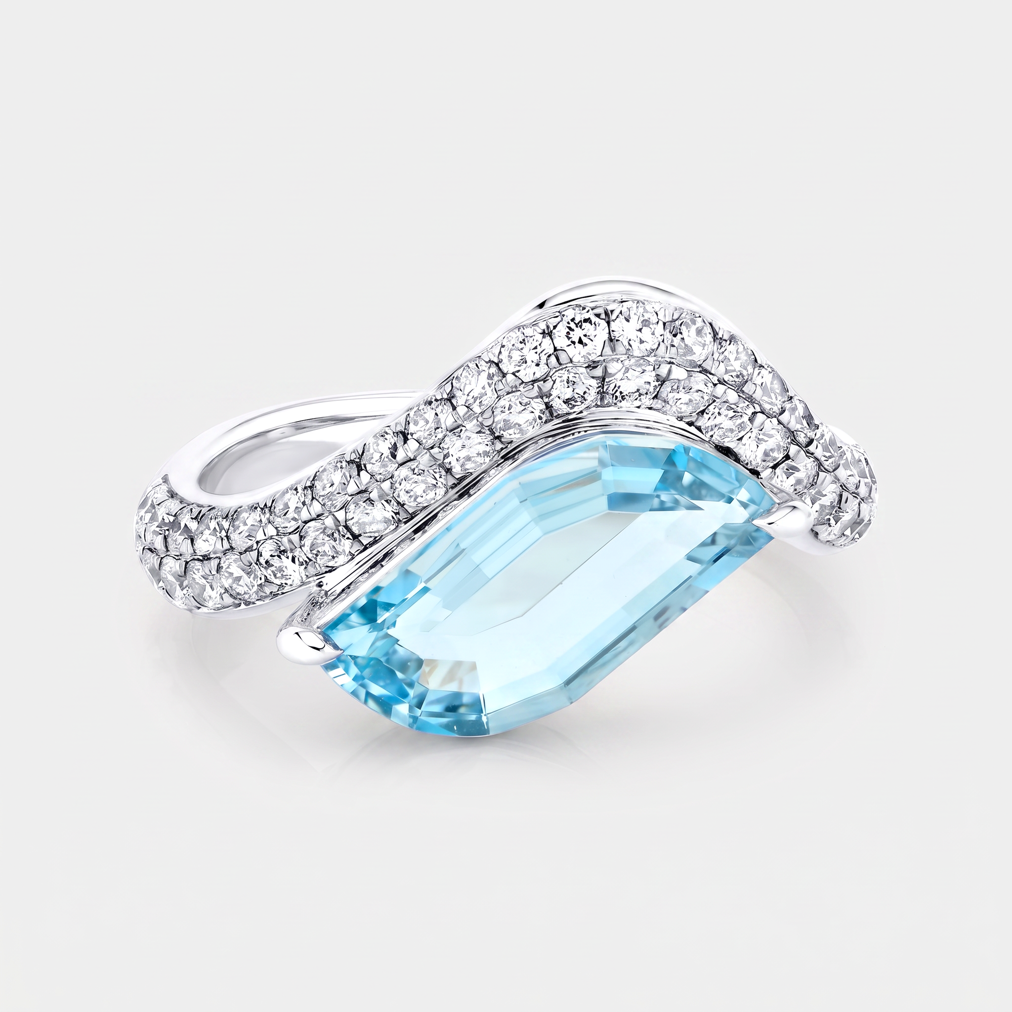 A white gold ring featuring a large, faceted light blue leaf cut aquamarine, flanked by a pavé-set band of clear round-cut stones, shown on a light gray background.