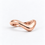 A polished rose gold ring with a smooth, flowing wavy design, photographed on a clean white background.