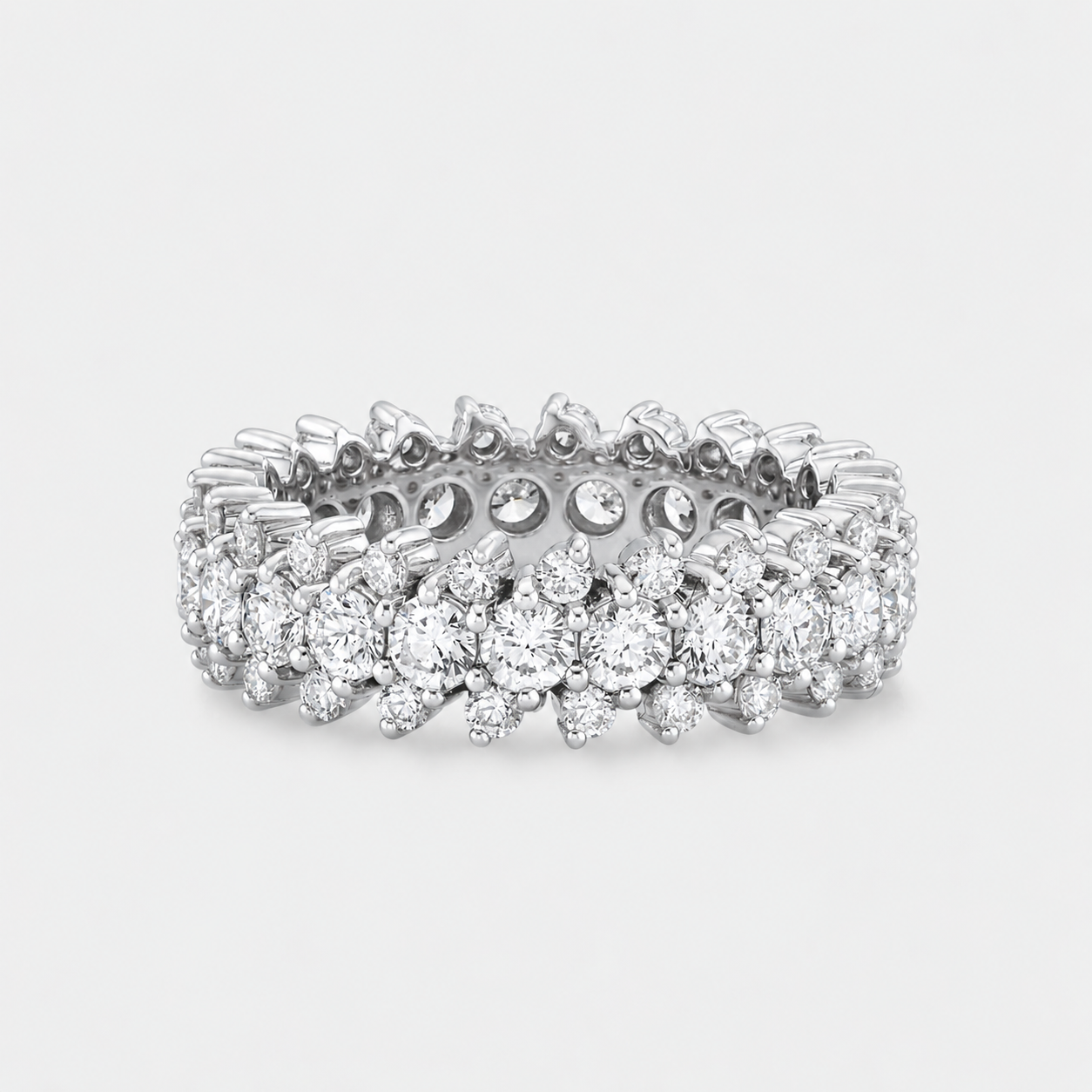 A silver-tone diamond eternity ring with a continuous line of round and cut diamonds, shown on a light gray background.