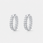 A pair of silver-tone hoop earrings adorned with multiple rows of diamonds, set against a light gray background.