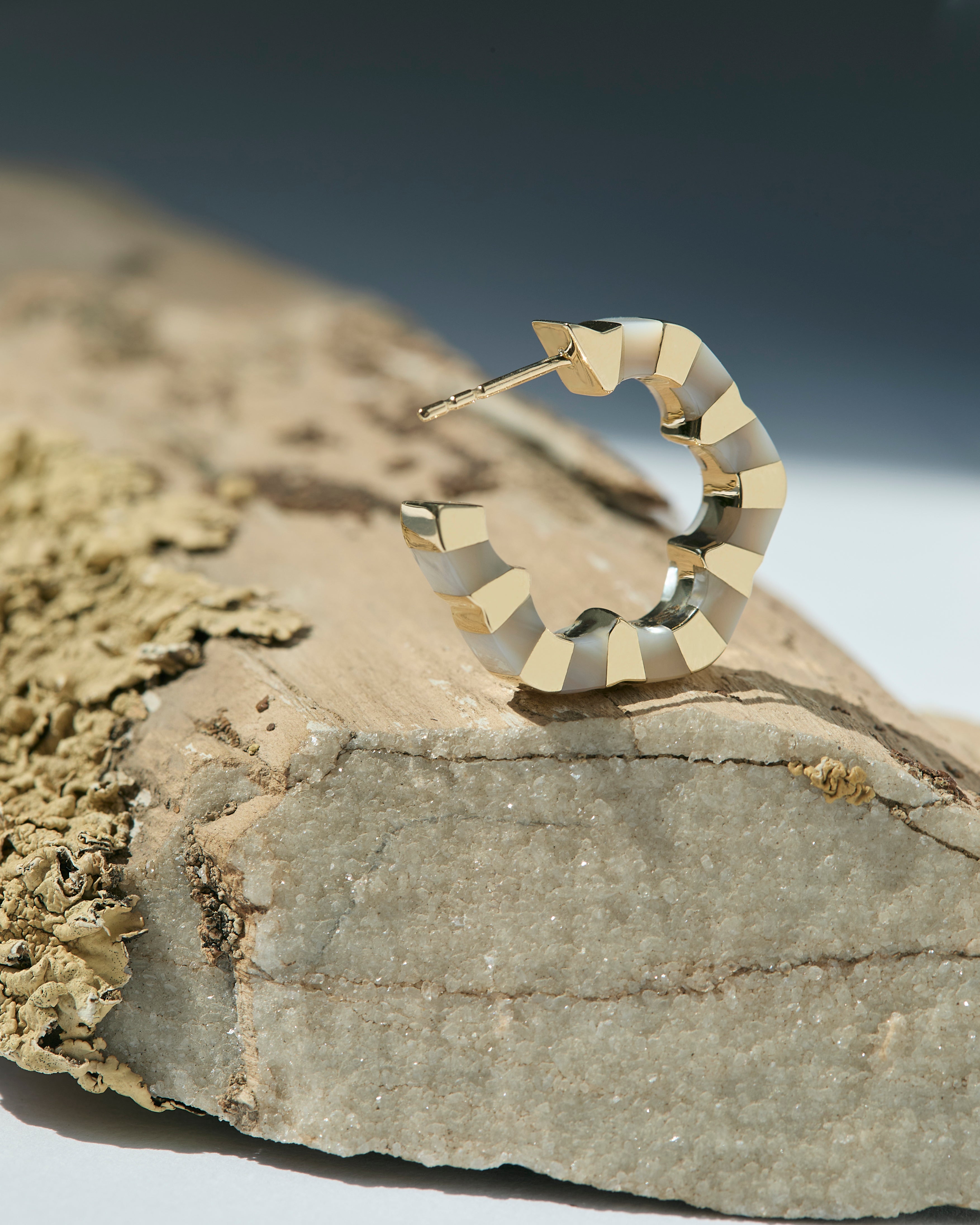 Gold and mother of pearl earrings designed by Isabel Delgado
