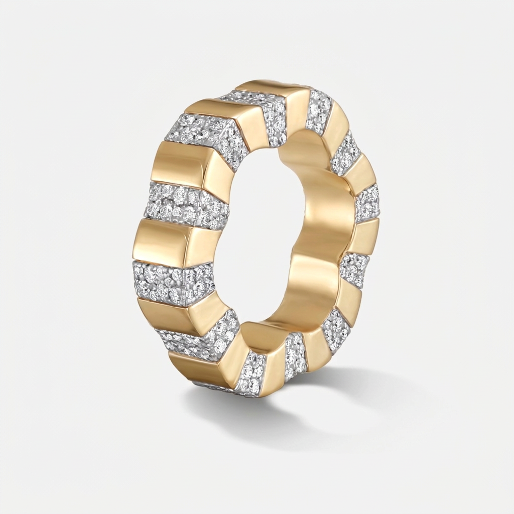 A wide yellow gold ring featuring a geometric, segmented chevron pattern with pavé-set clear diamonds on alternating sections, shown on a light gray background.