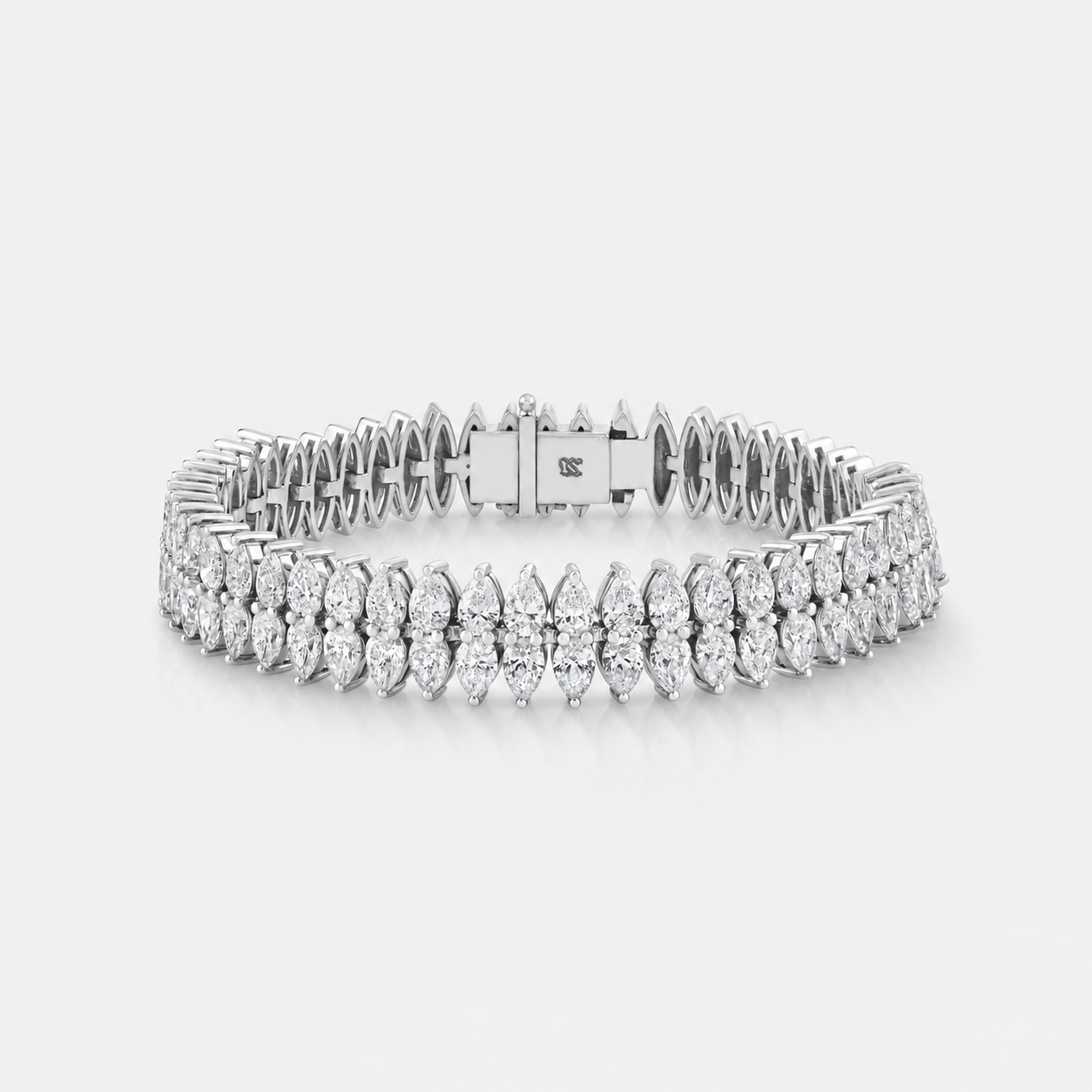 A silver tennis bracelet with rows of pear-cut and round diamonds, displayed on a clean light gray background.