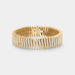 A yellow gold tennis bracelet featuring rows of pavé-set diamnds on the front and back, with a polished gold clasp visible at the back, set against a light gray background.