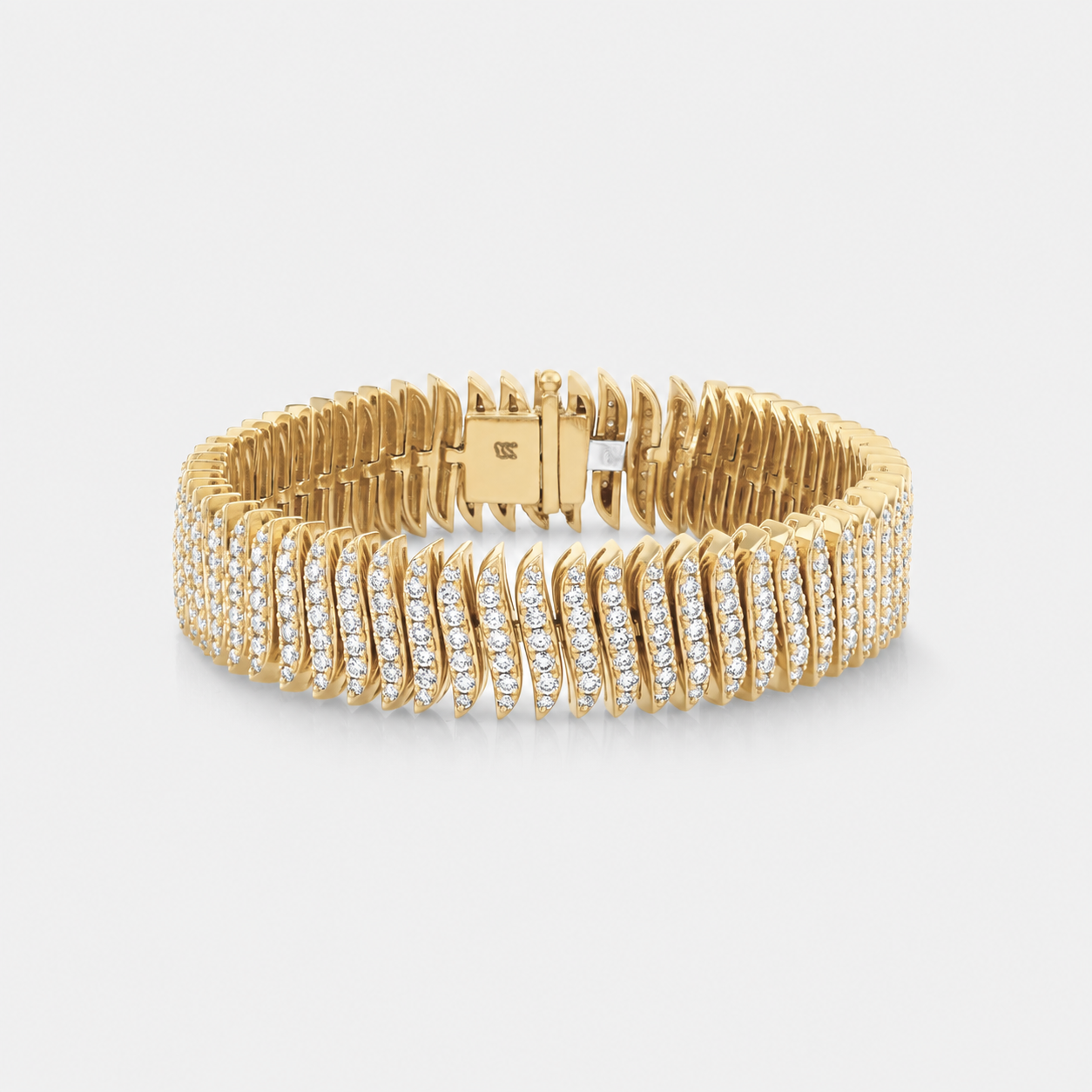A yellow gold tennis bracelet featuring rows of pavé-set diamnds on the front and back, with a polished gold clasp visible at the back, set against a light gray background.