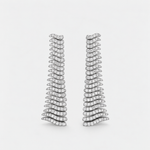 A pair of wavy, tiered drop earrings set with small diamonds in a silver-toned metal, displayed against a clean, light gray background.