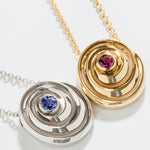 Catalina pendant designed by Isabel Delgado in a shape of a swirl crafted in gold and set with a pink tourmaline and a tanzanita