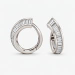 A pair of silver-toned huggie hoop earrings with baguette-cut clear diamonds, shown from two angles on a light gray background.