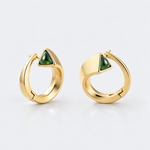 A pair of gold huggie hoop earrings with a small triangular green stone set on the front, displayed on a clean white background.