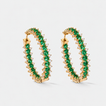A pair of gold hoop earrings adorned with a double row of round-cut green emeralds and small diamonds, set against a clean white background.