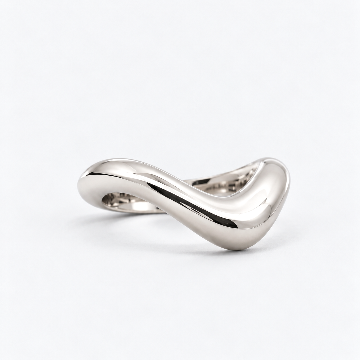 A polished silver ring with a smooth, flowing, wavy design, photographed on a clean white background.