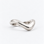 A polished silver ring with a smooth, flowing, wavy design, photographed on a clean white background.
