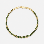 A gold necklace featuring a continuous row of marquise-cut green tourmalines, displayed on a clean light gray background.