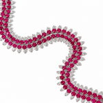 A close-up of a white-toned double-row necklace featuring round-cut vibrant pinkish-red rubies and round-cut clear stones, arranged in a wavy curve on a plain white background.