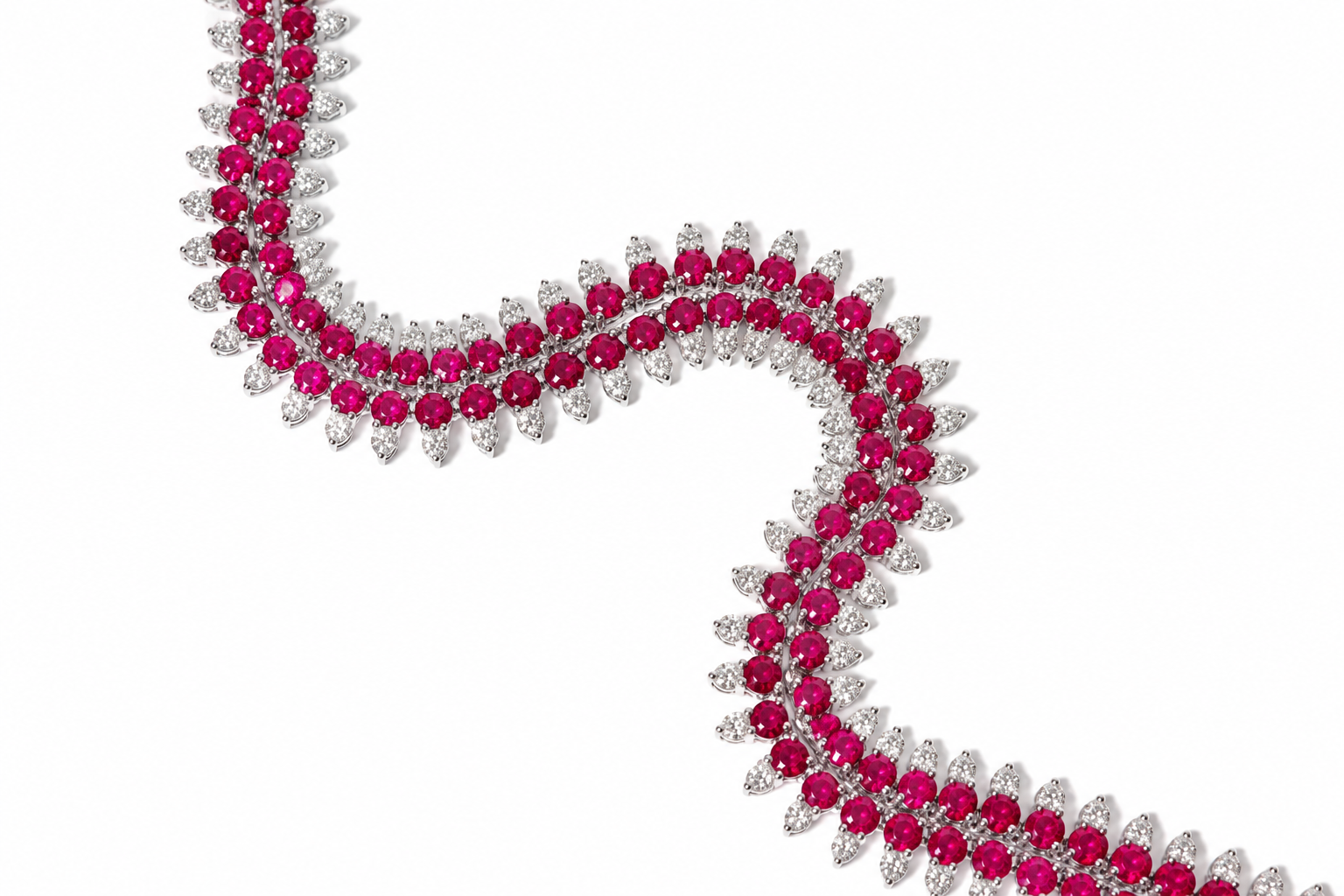 A close-up of a white-toned double-row necklace featuring round-cut vibrant pinkish-red rubies and round-cut clear stones, arranged in a wavy curve on a plain white background.