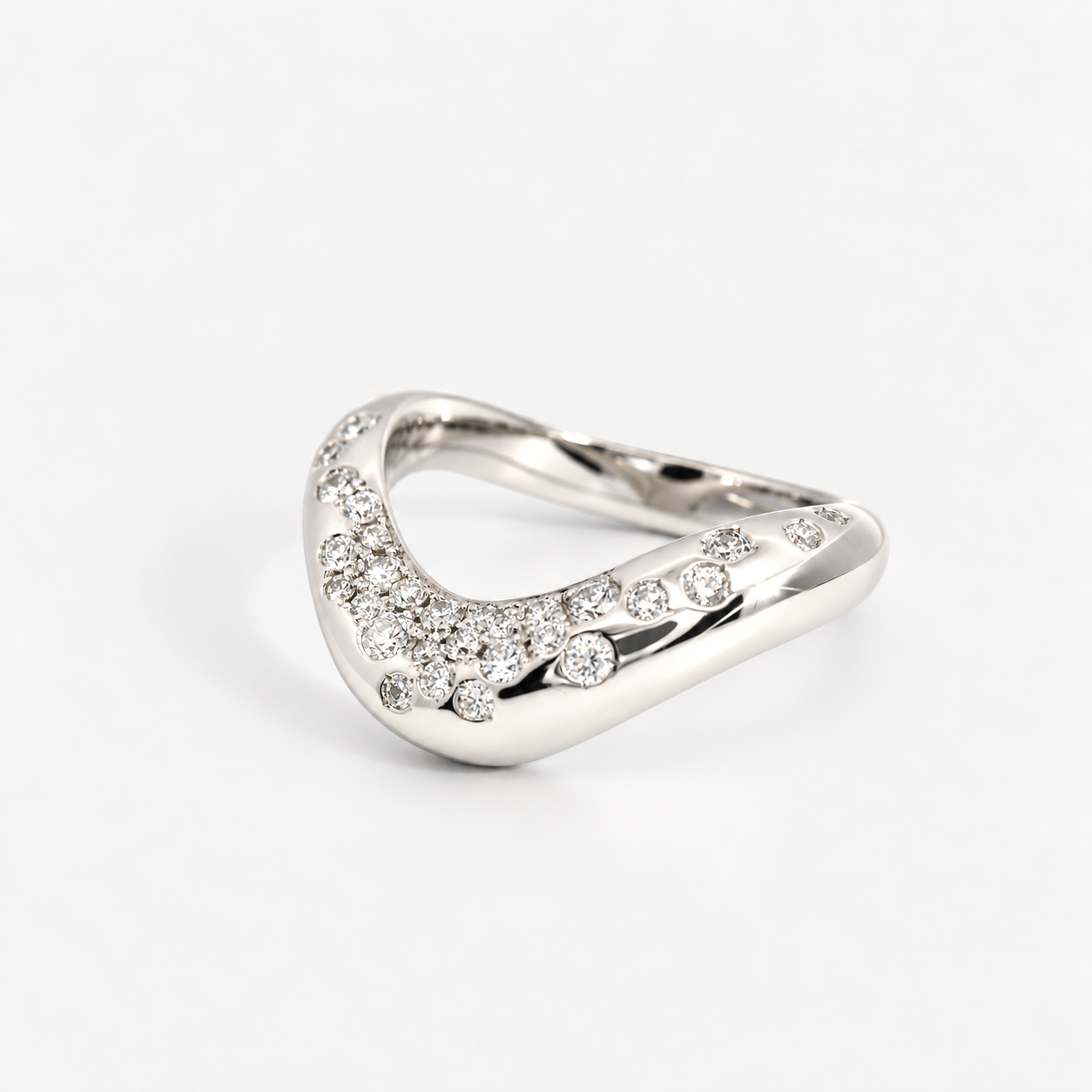 A silver-toned wavy ring adorned with pavé-set clear stones along the front curve, photographed on a clean light gray background.
