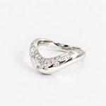 A silver-toned wavy ring adorned with pavé-set clear stones along the front curve, photographed on a clean light gray background.