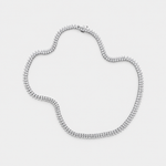 A silver tennis-style necklace with diamonds arranged in an irregular shape on a light gray background.