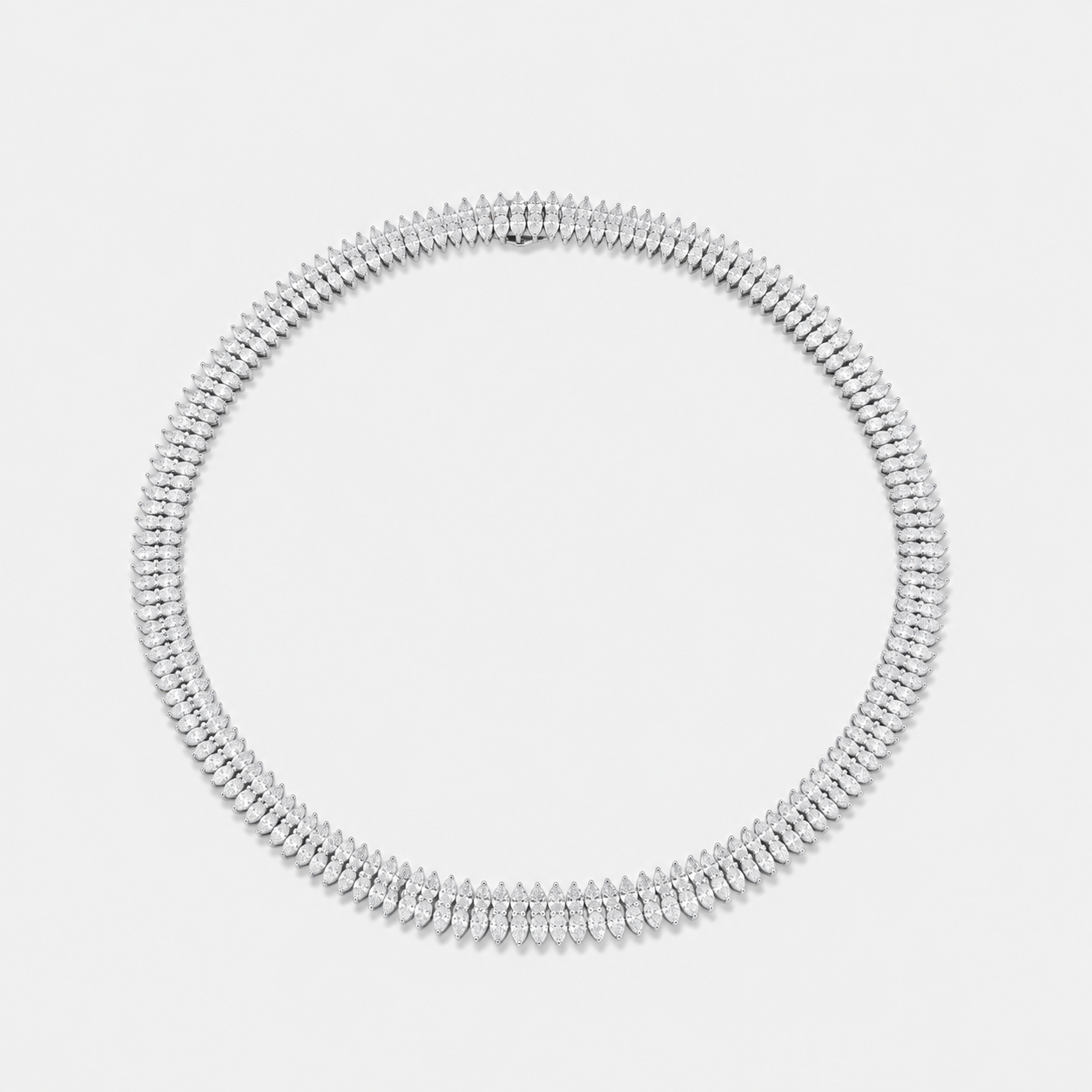 A silver-toned tennis necklace with pear cut diamonds shown on a light gray background.