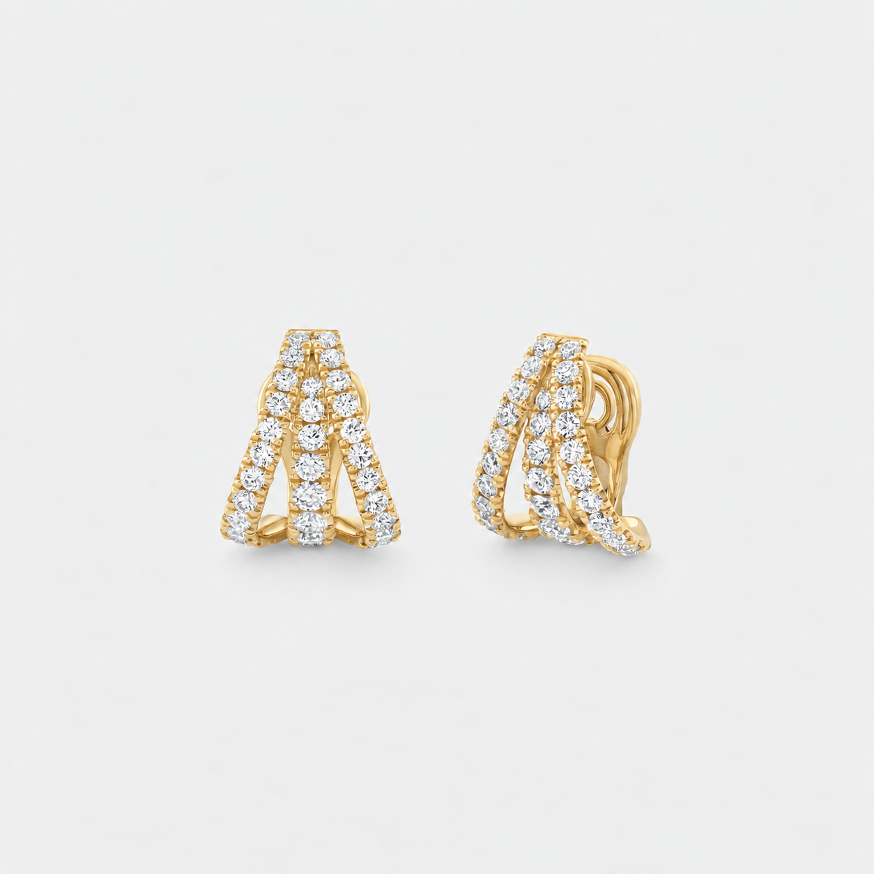A pair of gold huggie hoop earrings with pavé-set diamonds, shown from both front and side angles on a light gray background.